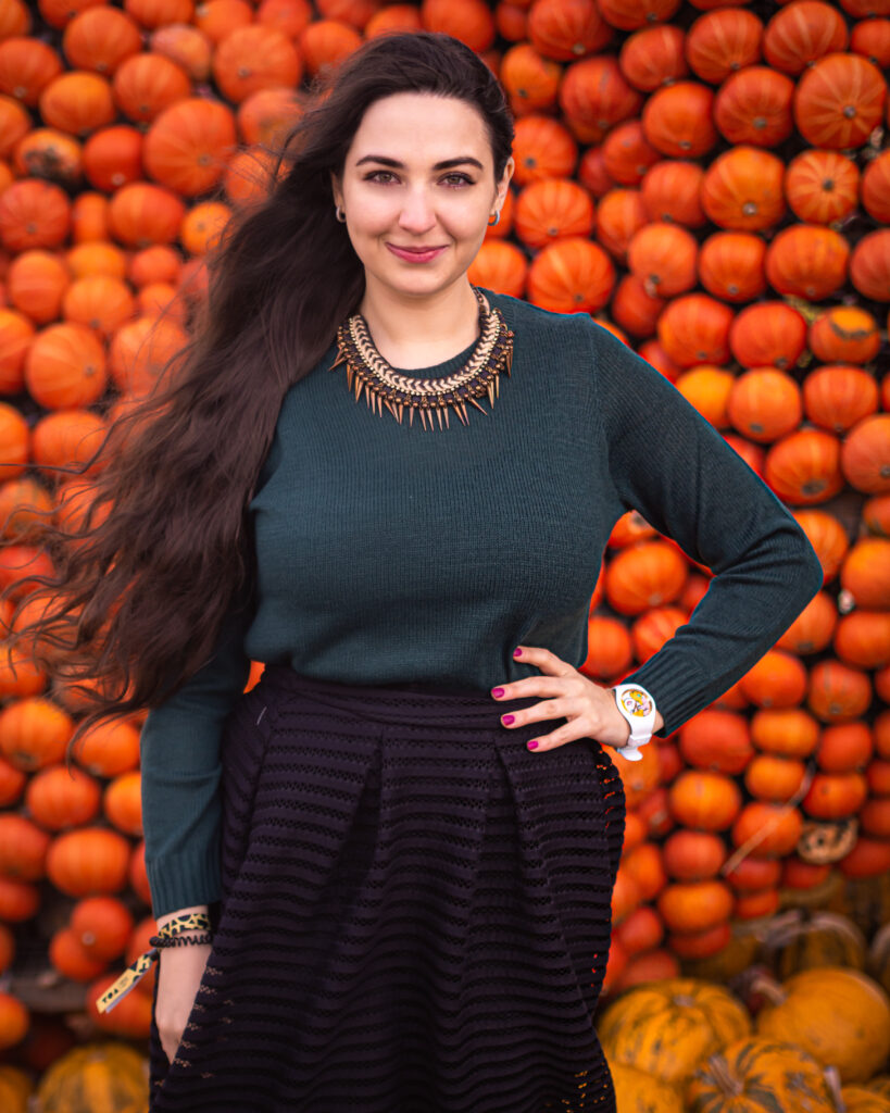 girl in front of a wall with pumpkins